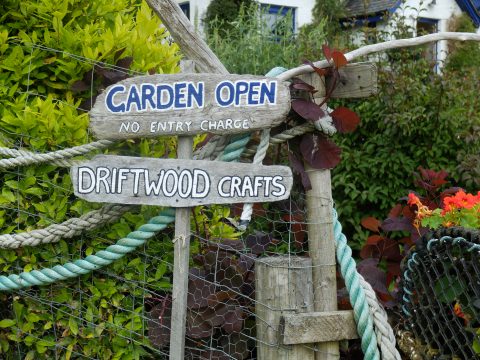 Driftwood signs proclaim 'Garden Open'.