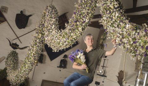 Volunteer, Caroline Bar, putting the finishing touches to the 60ft Christmas garland at Cotehele, Cornwall.